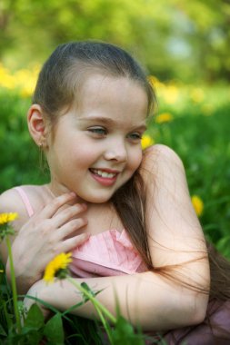 küçük kız glade ile dandelions oturur