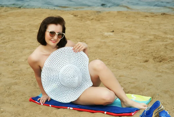A menina em uma praia em um chapéu branco . — Fotografia de Stock
