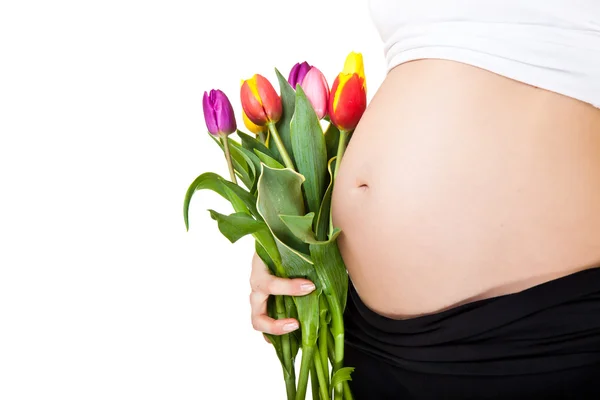 Terhes nő hasa tulipánvirággal — Stock Fotó
