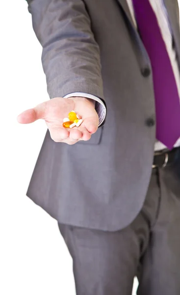 Человек в костюме держит таблетки изолированы на белом — стоковое фото