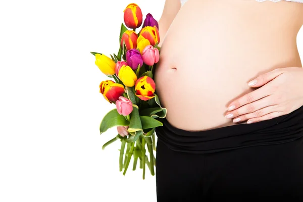 Mulher grávida barriga com flores de tulipa — Fotografia de Stock