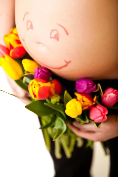 Pregnant woman belly with tulip flowers — Stock Photo, Image