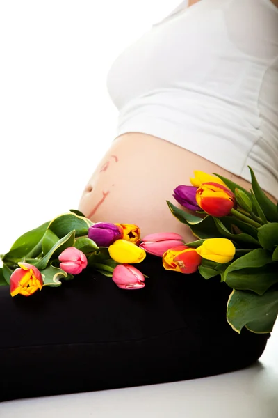 Ciężarna kobieta brzuch z kwiatów tulipan — Zdjęcie stockowe