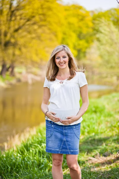 Беременная женщина на открытом воздухе весной — стоковое фото
