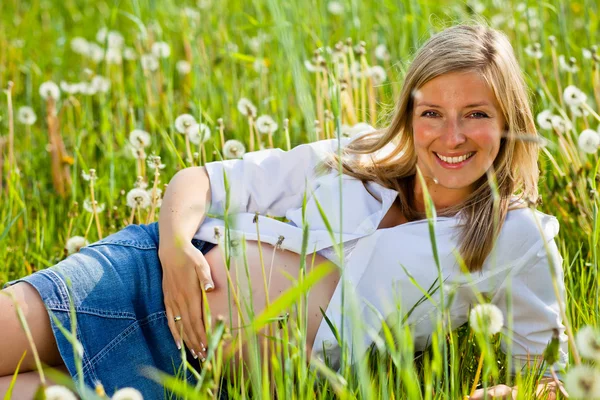 Вагітна жінка сидить на зеленому полі — стокове фото