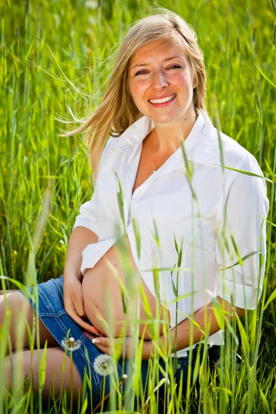 그린 필드에 앉아있는 임신한 여자 — 스톡 사진