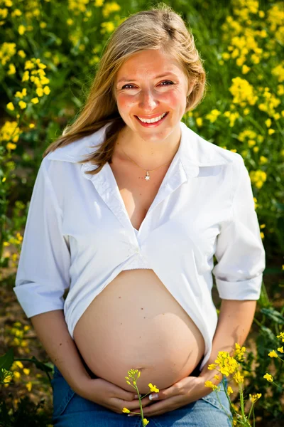 Mulher grávida sentada no campo verde — Fotografia de Stock