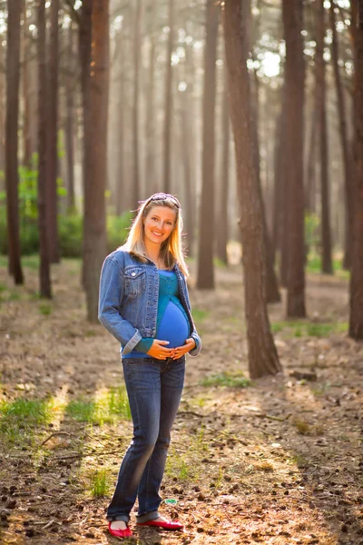 Schwangere sitzt auf der grünen Wiese — Stockfoto