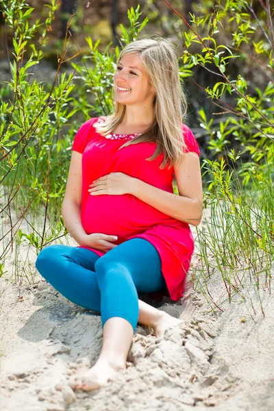 그린 필드에 앉아있는 임신한 여자 — 스톡 사진
