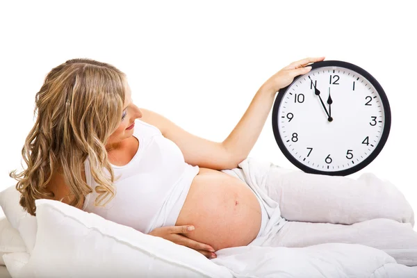 Zwangere vrouw met klok geïsoleerd op wit — Stockfoto