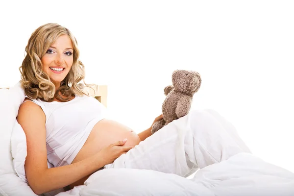 白で隔離されるベッドの中で妊娠中の女性 — ストック写真
