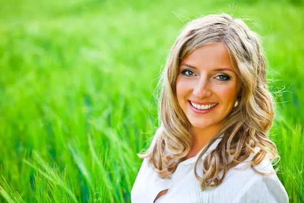 Blond woman portrait outdoor on green field — Stock Photo, Image