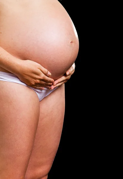 Mujer embarazada sobre fondo negro —  Fotos de Stock