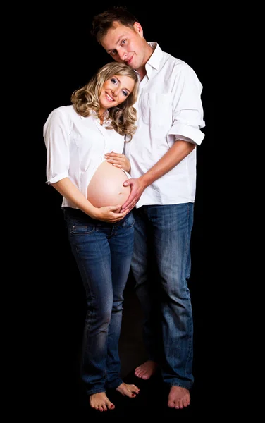 黒の背景に妊娠中のカップル — ストック写真