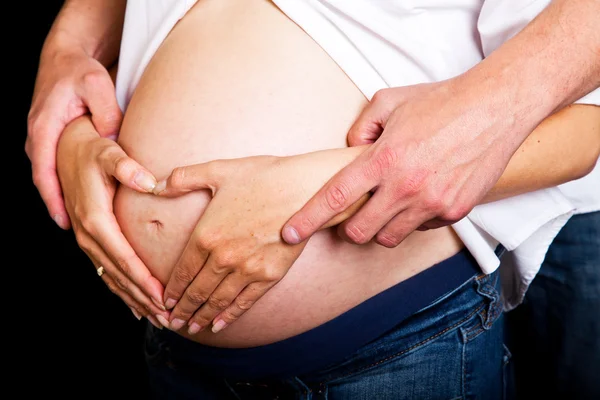 Těhotná žena na černém pozadí — Stock fotografie