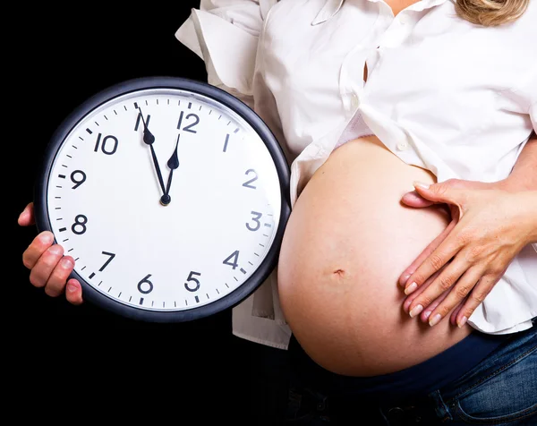 Концепция срока давности с беременным животом на черном — стоковое фото