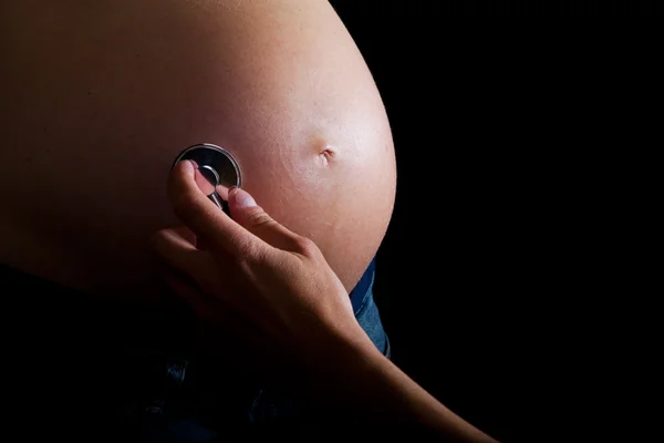 Mulher grávida no fundo preto — Fotografia de Stock