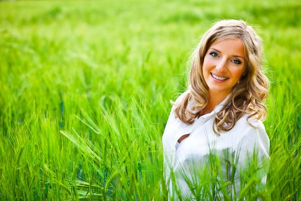 Blond kobieta portret odkryty na zielone pole — Zdjęcie stockowe