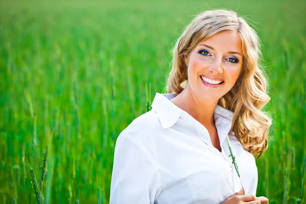 Blond woman portrait outdoor on green field — Stock Photo, Image