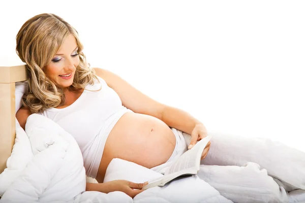 Kobieta w ciąży w łóżku na białym tle — Zdjęcie stockowe