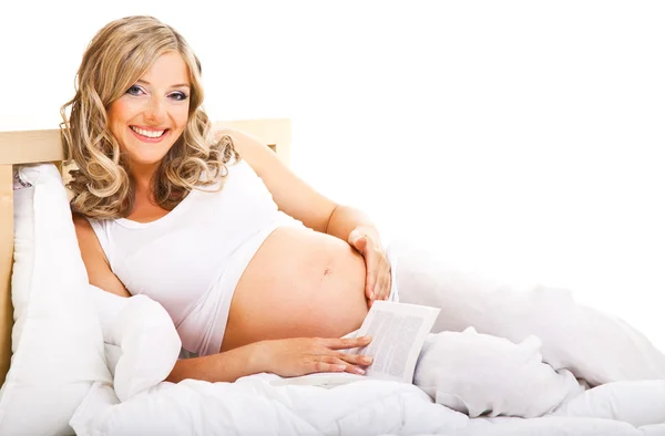 Έγκυος γυναίκα στο κρεβάτι που απομονώνονται σε λευκό — Φωτογραφία Αρχείου