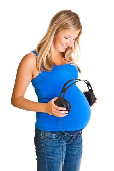 Беременная женщина с наушниками изолированы на белом — стоковое фото