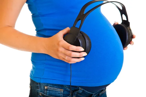 Těhotná žena se sluchátky izolovaných na bílém — Stock fotografie