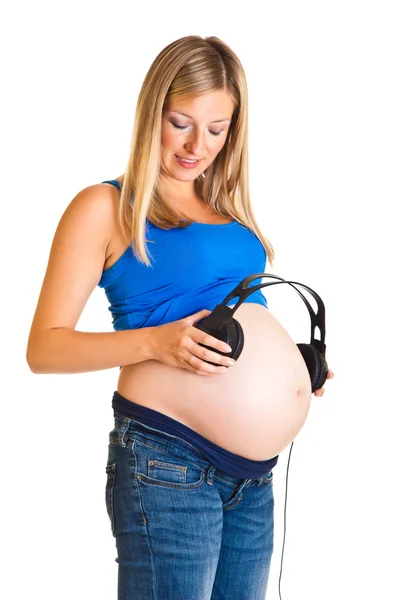 Donna incinta con cuffie isolate su bianco — Foto Stock