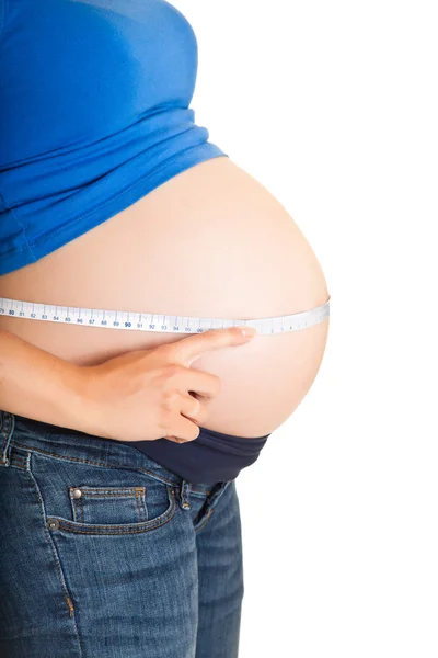 Pregnant woman measuring stomach isolated on white — Stock Photo, Image