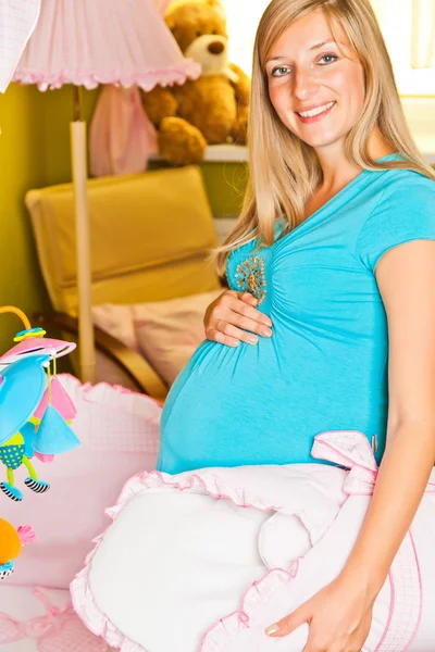 Mujer embarazada en habitación de bebé — Foto de Stock