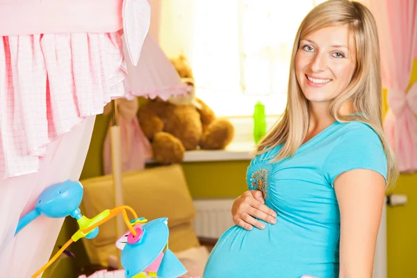 Mujer embarazada en habitación de bebé —  Fotos de Stock