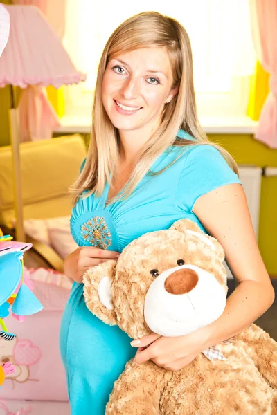 Mujer embarazada en habitación de bebé —  Fotos de Stock
