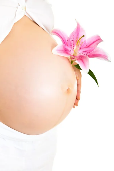 Беременная женщина, держащая лилии изолированными на белом — стоковое фото