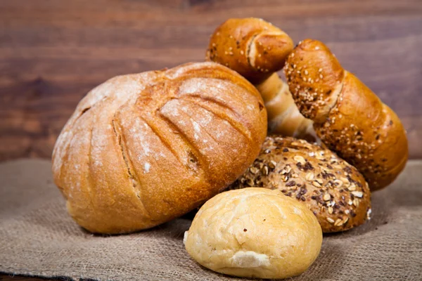 stock image Composition of fresh bread on wood