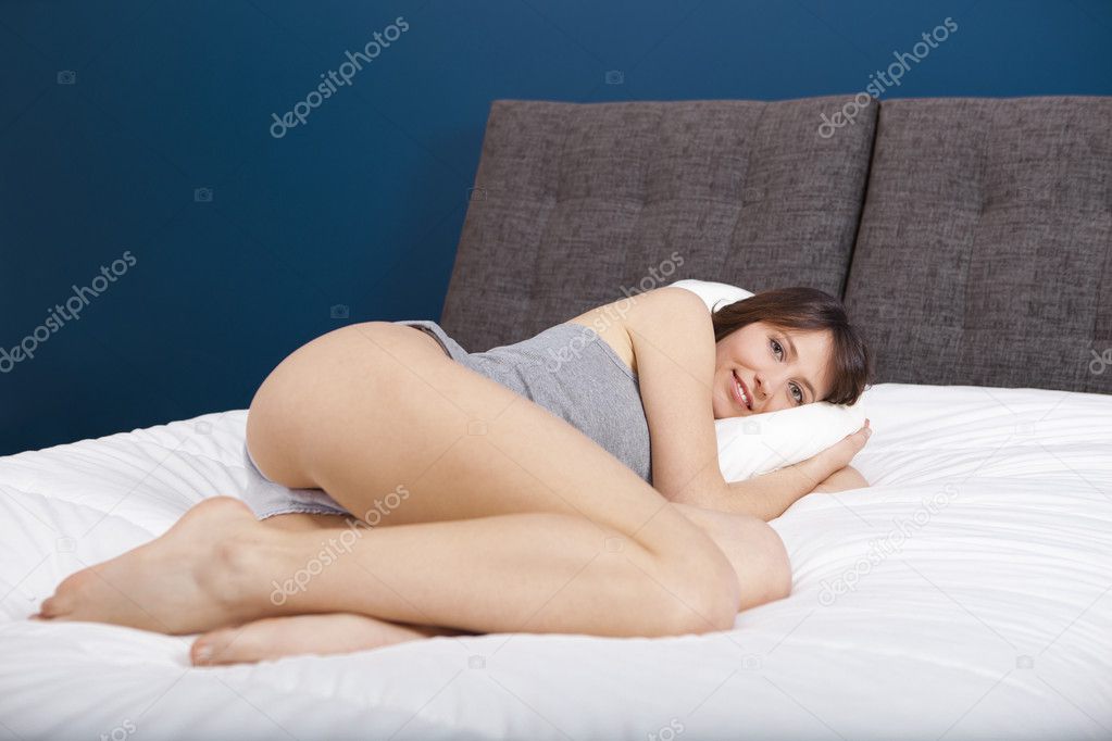 Девушка на кровати довольствуется трахом секс игрушкой