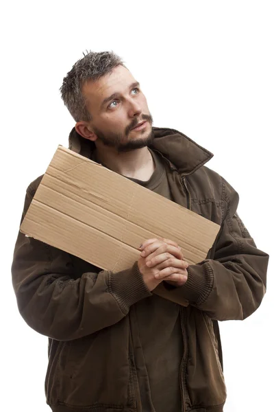 Mendigo sosteniendo cartón y rezar — Foto de Stock