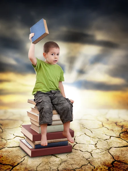 Criança sentada em livros — Fotografia de Stock