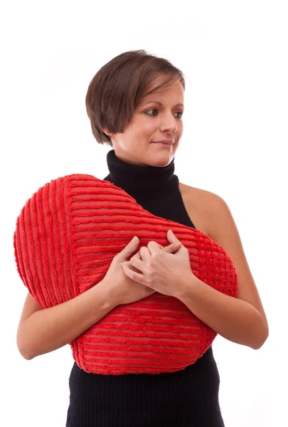 Donna abbracciare un cuscino a forma di cuore — Foto Stock