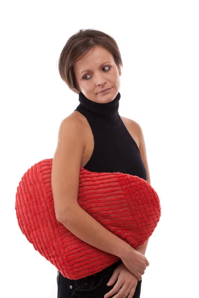 Mujer abrazar una almohada en forma de corazón —  Fotos de Stock
