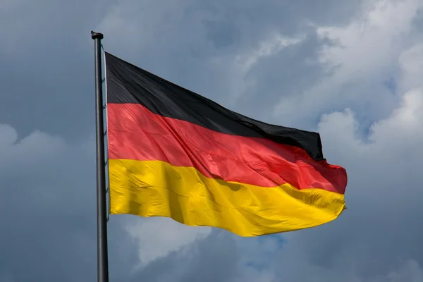 German flag in front of dark clouds — Stock Photo, Image