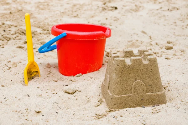 Zandkasteel met emmer en schop — Stockfoto