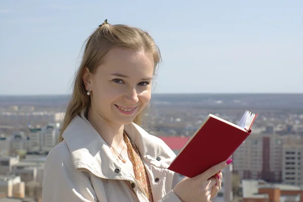 Chica leyendo un libro rojo — Foto de Stock