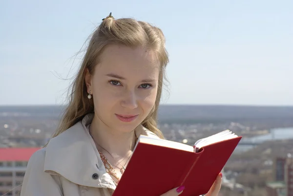 Donna che legge un libro rosso — Foto Stock