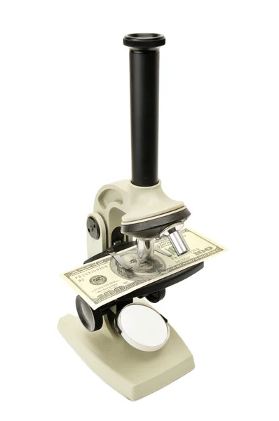 Микроскоп и деньги — стоковое фото