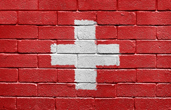 れんが造りの壁のスイス連邦共和国の旗 — ストック写真