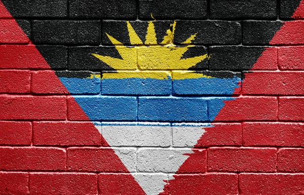 Vlajka Antiguy a Barbudy na cihlovou zeď — Stock fotografie