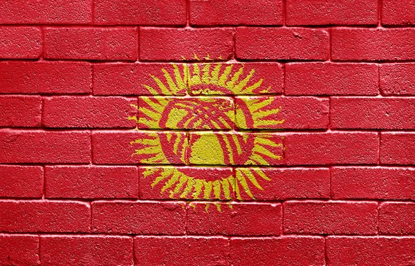 レンガの壁にキルギスタンの旗 — ストック写真