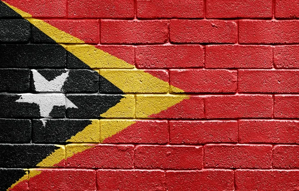 Bandera de Timor Oriental sobre muro de ladrillo — Foto de Stock