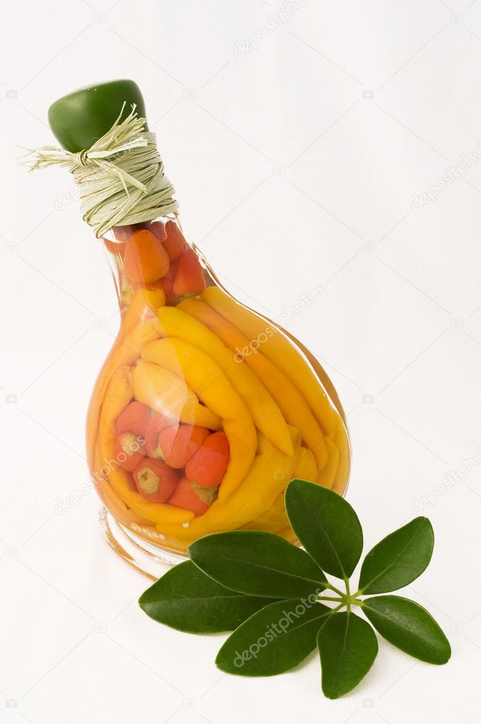 Red and orange peppers in a glass bottle