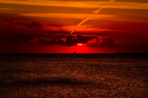 Puesta de sol misteriosa sobre el mar Rojo. Sol, cielo colorido y nubes sobre el mar oscuro —  Fotos de Stock